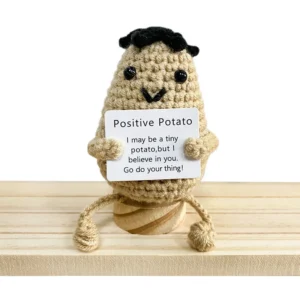 I have displayed the image you provided. Based on the visual and the text you shared, here is the suggested title:  "Emocjonalne wsparcie w postaci uroczej szydełkowej lalki-ogórka"