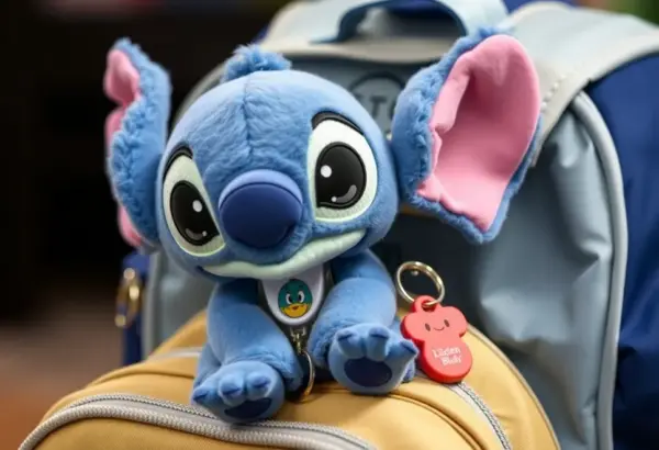 A plush toy of Stitch sitting on a backpack.