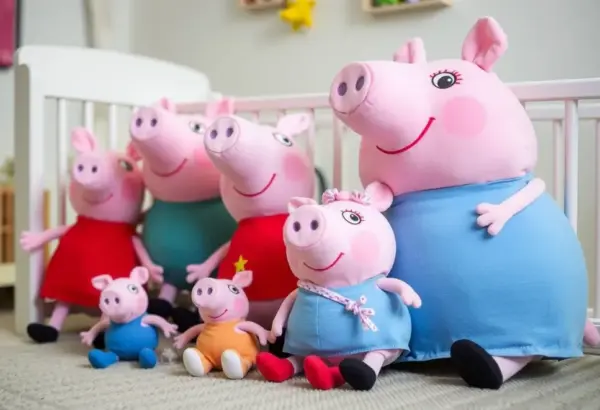 Various Peppa Pig plush toys in a nursery.
